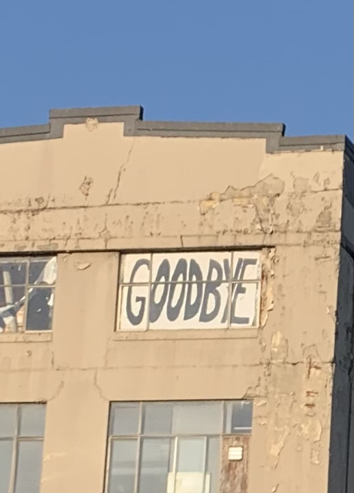 sign in an abandoned building reading 'goodbye'
